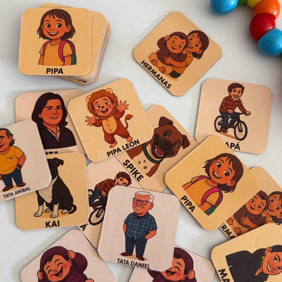 Cartas físicas de Memoripa esparcidas mostrando caricaturas personalizadas de familia: Pipa, Domi, Tata Daniel, Mamá, mascotas y más